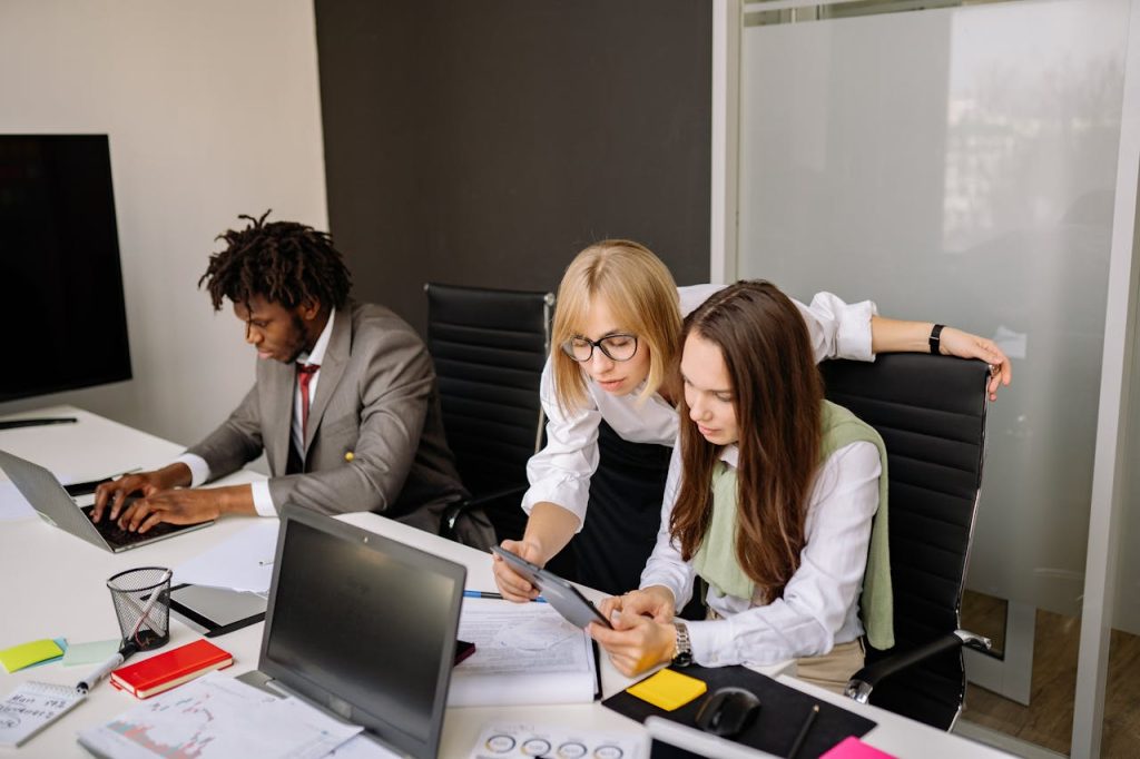 pexels-photo-7792771 Business team collaborating in a modern office setting with laptops and tablets.